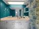 The bathroom is decorated with teal paint, a floral curtain, and a white vanity with storage at 1141 Milstead Ne Ave, Conyers, GA 30012