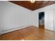 Bright bedroom featuring hardwood floors, wood paneled ceiling, white walls, and radiator at 1141 Milstead Ne Ave, Conyers, GA 30012