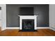 Close up of the living room fireplace on gray accent wall with hardwood floors at 1141 Milstead Ne Ave, Conyers, GA 30012