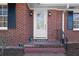 Charming brick home entrance with glass-paneled door and decorative black shutters at 1141 Milstead Ne Ave, Conyers, GA 30012