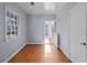 Hallway with hardwood floors leads to open doorway and a window at 1141 Milstead Ne Ave, Conyers, GA 30012