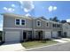 Modern townhome exteriors featuring neutral siding, garages, and well-manicured lawns under a bright sky at 206 Gillis Sw Way, Villa Rica, GA 30180