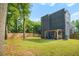 Large backyard with a modern house, green grass, a wooden fence, and covered patio at 244 Locust Ne St # B, Atlanta, GA 30317