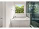 Bathroom showcasing a soaking tub with marble surround and a glass-enclosed shower at 244 Locust Ne St # B, Atlanta, GA 30317