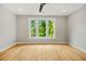 Spacious bedroom featuring hardwood floors and three windows with green trees at 244 Locust Ne St # B, Atlanta, GA 30317