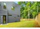 View of the side of the modern home with a grass lawn, wooden fence, and greenery at 244 Locust Ne St # B, Atlanta, GA 30317