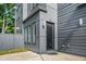 Stylish home entrance with a black framed door, gray siding, and a well manicured lawn at 244 Locust Ne St # B, Atlanta, GA 30317