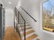 Contemporary staircase with wooden steps, metal railings, hardwood flooring, and a large window at 244 Locust Ne St # B, Atlanta, GA 30317