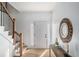 Entryway featuring light wood flooring, a staircase, and a stylish decorative mirror at 3001 W Potomac Dr, Atlanta, GA 30344