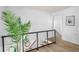 Hallway with wood floors, a plant, and a modern glass railing at 3001 W Potomac Dr, Atlanta, GA 30344