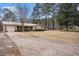 Well-maintained ranch-style home with long driveway and metal roof, surrounded by mature trees at 4775 Hemlock Se Dr, Conyers, GA 30094