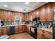 Functional kitchen featuring granite countertops, stainless steel appliances, and dark wood cabinetry at 4775 Hemlock Se Dr, Conyers, GA 30094