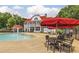 Inviting pool area with tables, umbrellas, and a large two-story house in a private community at 654 Egrets Lot 65 Lndg, Covington, GA 30014