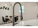 Modern kitchen faucet over a white kitchen island with decor and a dining area in the background at 1218 Crestwood Se Dr, Atlanta, GA 30316