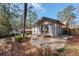 A backyard showcasing a stone patio, gray exterior, and mature trees at 3401 Lori Ln, Atlanta, GA 30340