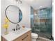 Modern bathroom boasts glass-enclosed shower with unique tile, sleek vanity, and stylish round mirror at 3401 Lori Ln, Atlanta, GA 30340