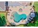 Aerial view of a backyard oasis featuring a freeform pool, hot tub, patio, lounge seating, and lush landscaping at 5040 Blackberry Ln, Buford, GA 30518