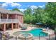 Spacious backyard featuring an in-ground pool, spa, patio, and covered seating area, perfect for outdoor living at 5040 Blackberry Ln, Buford, GA 30518