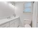 Bright bathroom features white cabinets, quartz countertops, a window and a sleek lighting fixture at 5040 Blackberry Ln, Buford, GA 30518