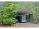 Covered car port surrounded by greenery, provides protection from the elements at 5040 Blackberry Ln, Buford, GA 30518