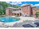 A large in-ground pool in a backyard of a red brick home offers relaxation and entertainment at 5040 Blackberry Ln, Buford, GA 30518