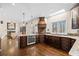 View of the kitchen with dark cabinets, granite countertops, stainless appliances and open to the living room at 735 Amberton Close, Suwanee, GA 30024