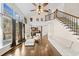 Bright living room featuring hardwood floors, a staircase leading to the upper level and large windows at 735 Amberton Close, Suwanee, GA 30024