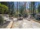 Serene backyard featuring a stone patio with a fire pit and comfortable seating surrounded by nature at 1835 Berkeley Ne Mews, Atlanta, GA 30329