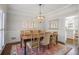 Elegant dining room with wainscoting, modern chandelier, and view into kitchen area at 1835 Berkeley Ne Mews, Atlanta, GA 30329