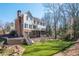 Exterior rear view of a two-story home with a brick chimney, a deck, a screened porch, and a retaining wall at 1835 Berkeley Ne Mews, Atlanta, GA 30329