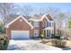 Traditional brick home featuring a two-car garage, manicured landscaping, and a charming front entrance at 1835 Berkeley Ne Mews, Atlanta, GA 30329