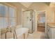 Bright main bathroom featuring a soaking tub, glass-enclosed shower, and dual vanities at 1835 Berkeley Ne Mews, Atlanta, GA 30329