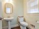 Charming powder room with patterned wallpaper and a pedestal sink at 1835 Berkeley Ne Mews, Atlanta, GA 30329