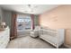 Cozy Bedroom featuring a white crib, comfortable chair, and soft pink accents for a soothing atmosphere at 2230 Rosemoore Walk, Marietta, GA 30062