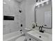 Bathroom featuring marble-look tile, black hardware, and a bathtub/shower combo at 543 Paines Nw Ave, Atlanta, GA 30318