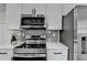 Modern kitchen features stainless steel appliances, white cabinets, and a gray backsplash at 543 Paines Nw Ave, Atlanta, GA 30318