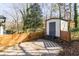 Backyard shed features a modern fence, concrete pad, and neutral color palette at 1300 Wichita Sw Dr, Atlanta, GA 30311