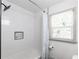 Bright bathroom featuring a shower with white tile and convenient built-in shelving at 1300 Wichita Sw Dr, Atlanta, GA 30311