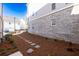 Townhome backyard has a stone pathway, mulch ground cover and a grey brick facade at 167 Basil Street Dr, Cumming, GA 30040