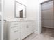 Bathroom featuring a white vanity with ample storage, modern fixtures, and a mirror, adjacent to a walk-in closet at 167 Basil Street Dr, Cumming, GA 30040
