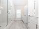 Bathroom showcasing a glass-enclosed shower, white cabinetry, and a bright window, all with neutral tiling at 167 Basil Street Dr, Cumming, GA 30040