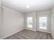 Bedroom showcasing neutral carpeting, two windows, and a central ceiling light, offering a simple and bright living space at 167 Basil Street Dr, Cumming, GA 30040