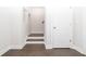 Hallway features hardwood flooring, neutral walls, and a staircase, creating a smooth transition between spaces at 169 Basil Street Dr, Cumming, GA 30040