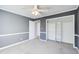 A gray bedroom featuring plush carpeting, white trim, and a ceiling fan with a light fixture at 3721 Stonewall Se Cir, Atlanta, GA 30339