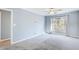 A spacious bedroom with plush carpeting, large window with coverings, and a view to a hallway at 3721 Stonewall Se Cir, Atlanta, GA 30339