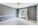 This bedroom has neutral carpet and trim, a ceiling fan, and a large window at 3721 Stonewall Se Cir, Atlanta, GA 30339