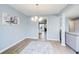 Dining area with modern chandelier, light blue walls, and view into adjacent kitchen and living spaces at 3721 Stonewall Se Cir, Atlanta, GA 30339