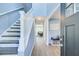 Inviting hallway with staircase, light blue walls, wood-look flooring, and open view to living area at 3721 Stonewall Se Cir, Atlanta, GA 30339