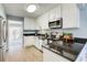 Well-lit kitchen featuring white cabinetry, black countertops, stainless steel appliances, and open layout at 3721 Stonewall Se Cir, Atlanta, GA 30339