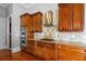 Close-up of gourmet kitchen with cherry wood cabinets, stainless steel appliances, granite counters, and tiled backsplash at 956 Shadowford Fls, Lithonia, GA 30058